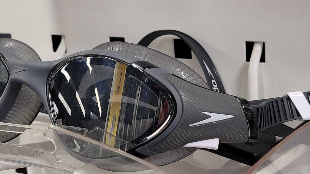 Detailansicht einer getönten, grauen Schwimmbrille im Test, die in einem Verkaufsbereich ausgestellt ist.