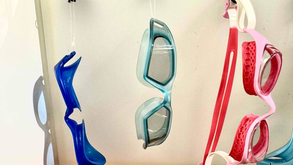 Detailansicht von mehreren an Schnüren hängenden getesteten Speedo-Schwimmbrillen in unterschiedlichen Farben.