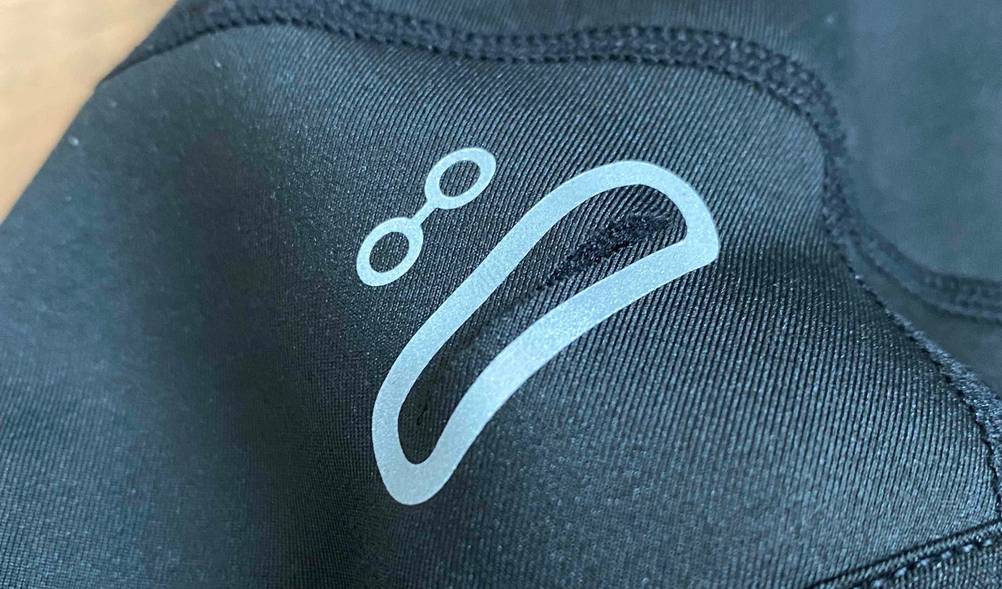 Nahaufnahme der Aussparung für Kopfhörerkabel einer getesteten Fahrradhelm-Unterziehmütze in Schwarz.