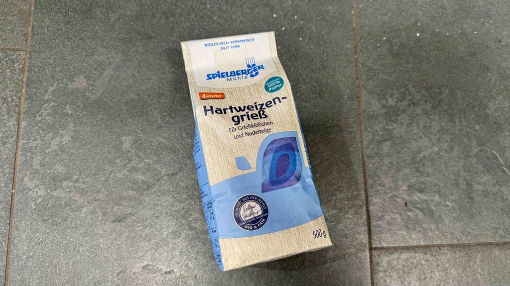Eine Packung getesteter Hartweizengrieß liegt auf einer grauen Oberfläche.