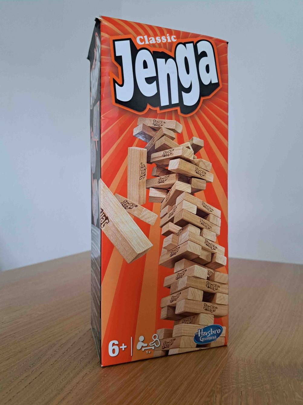 Originalverpackung eines Spiels ab 6 Jahren im Test auf einer Holzfläche stehend.