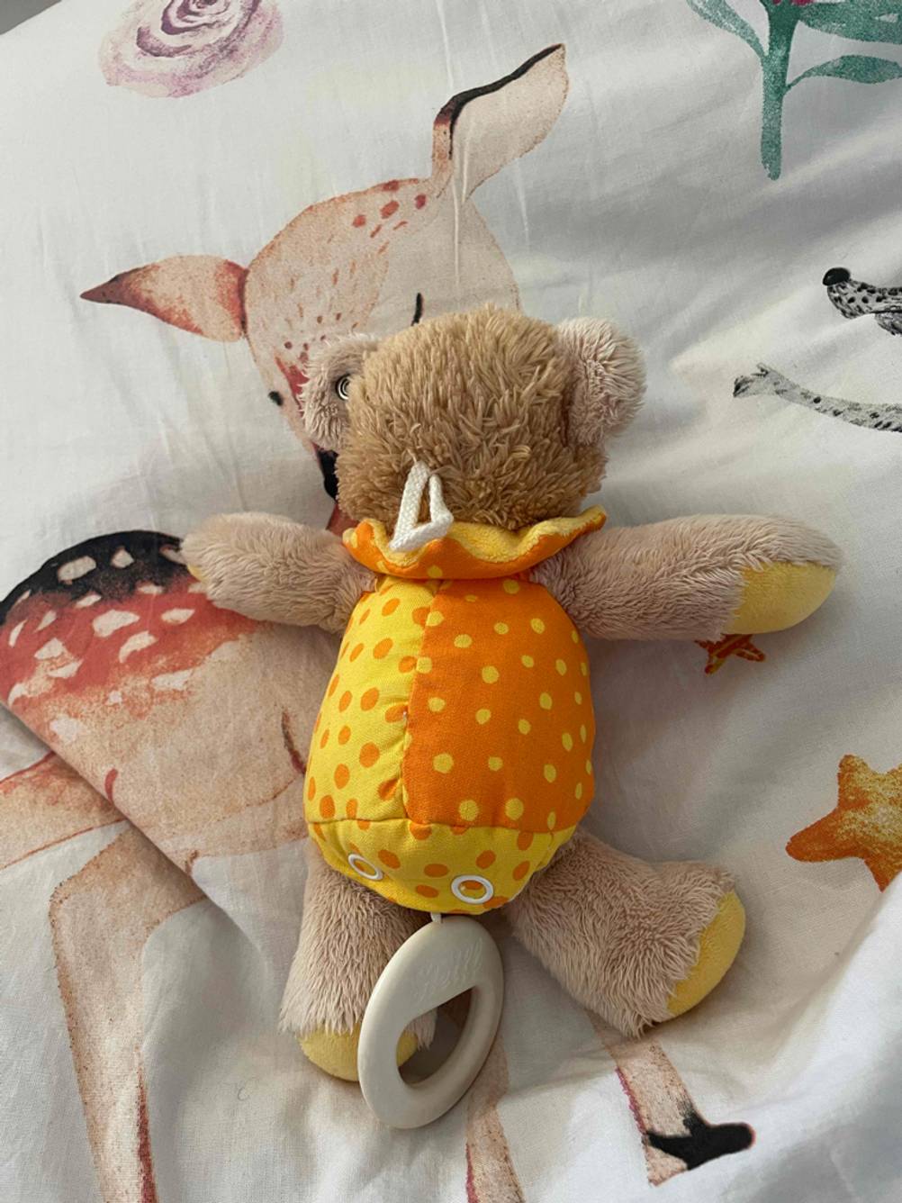 Auf dem Bett liegt eine getestete Spieluhr für Babys.