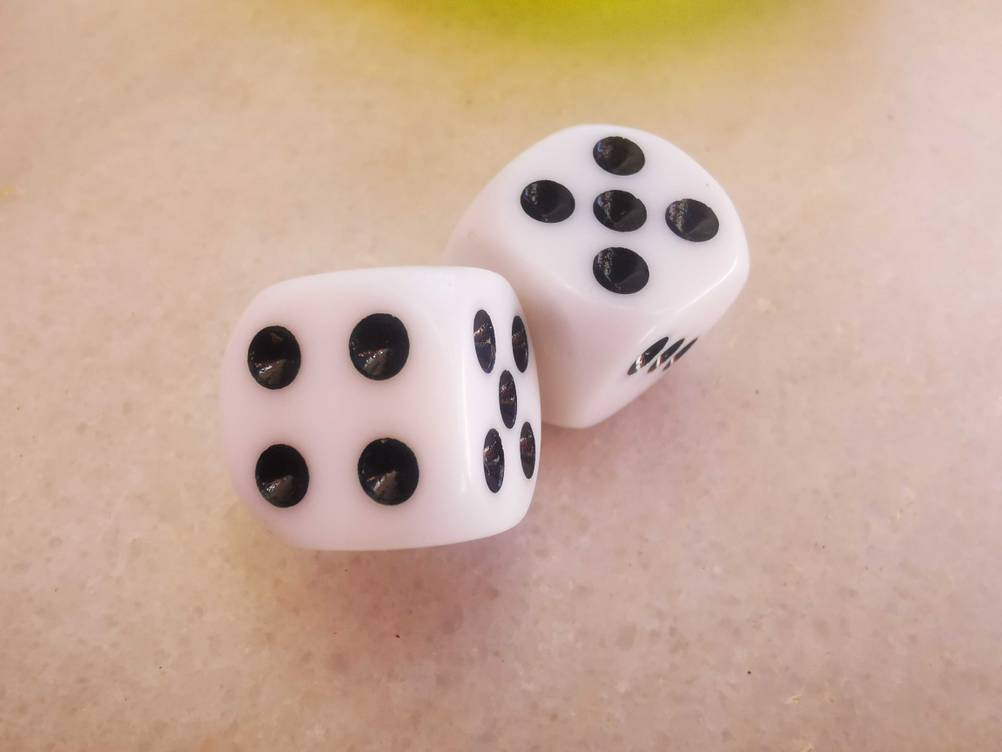Spielwürfel-Test: Zwei Würfel auf einer hellen Fläche.