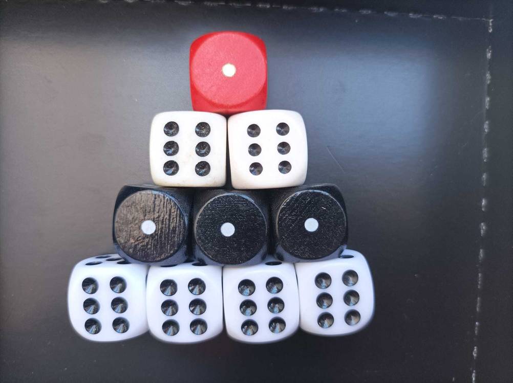 Mehrere unterschiedlich farbige Spielwürfel im Test zu einer Pyramide angeordnet.