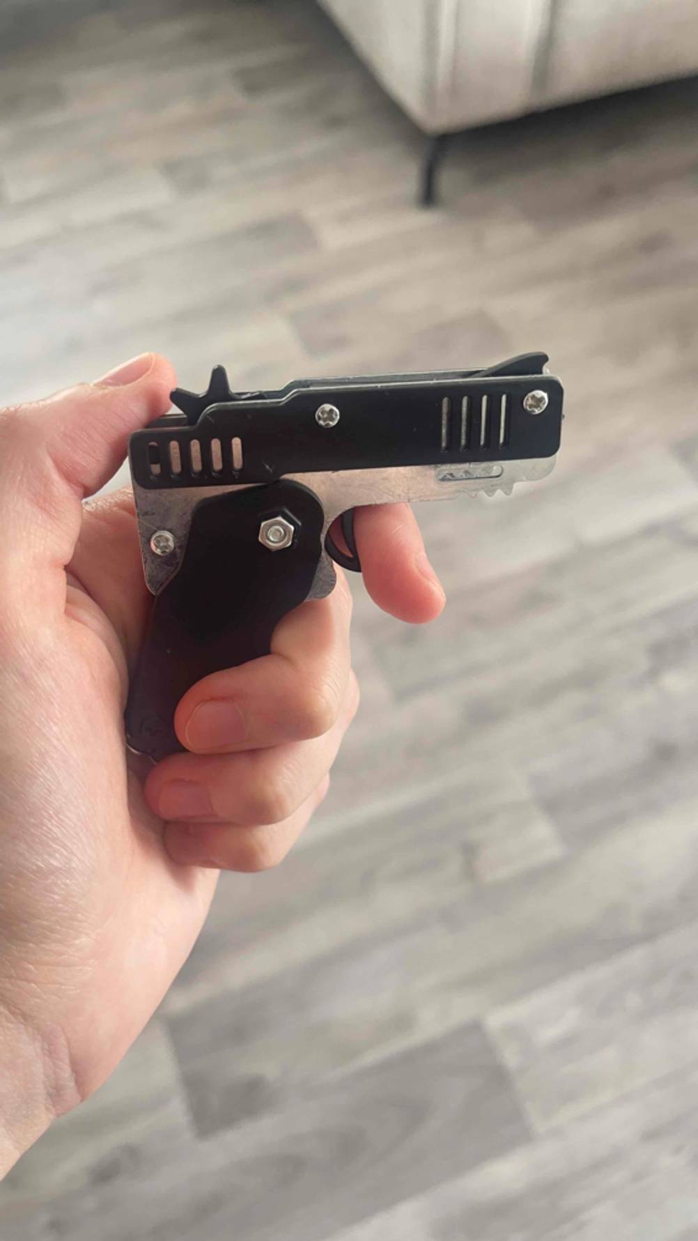 Eine Hand hält die Spielzeugpistole im Test.