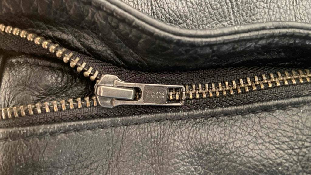 Nahaufnahme einer schwarzen, getesteten Lederhose mit Fokus auf den Reißverschluss.