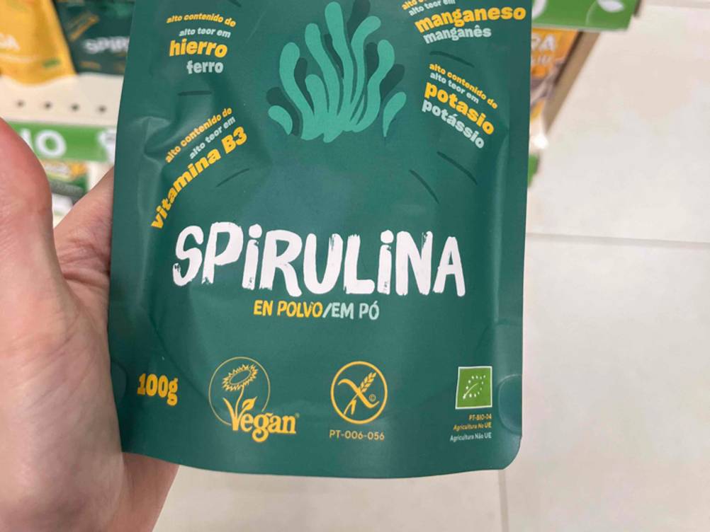 Spirulina-Pulver getestet: Nahaufnahme der Verpackung von einer Hand gehalten.