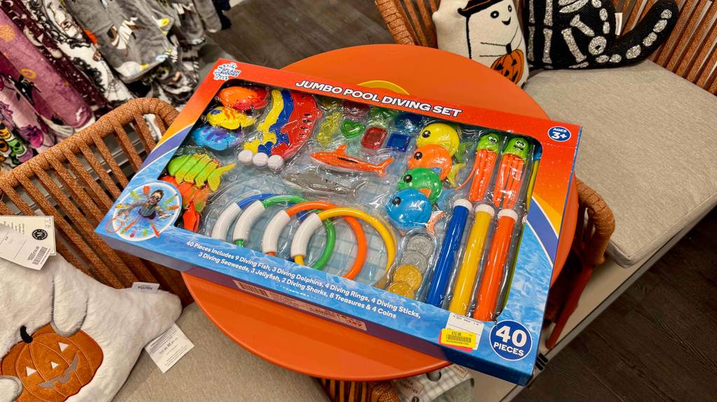 Auf einem orangefarbenen Tisch liegt die Verpackung mit dem getesteten Tauchspielzeug, das aus 40 bunten Einzelteilen besteht.