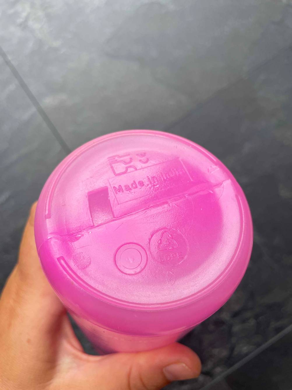 Boden einer getesteten Sport-Trinkflasche von einer Hand gehalten.