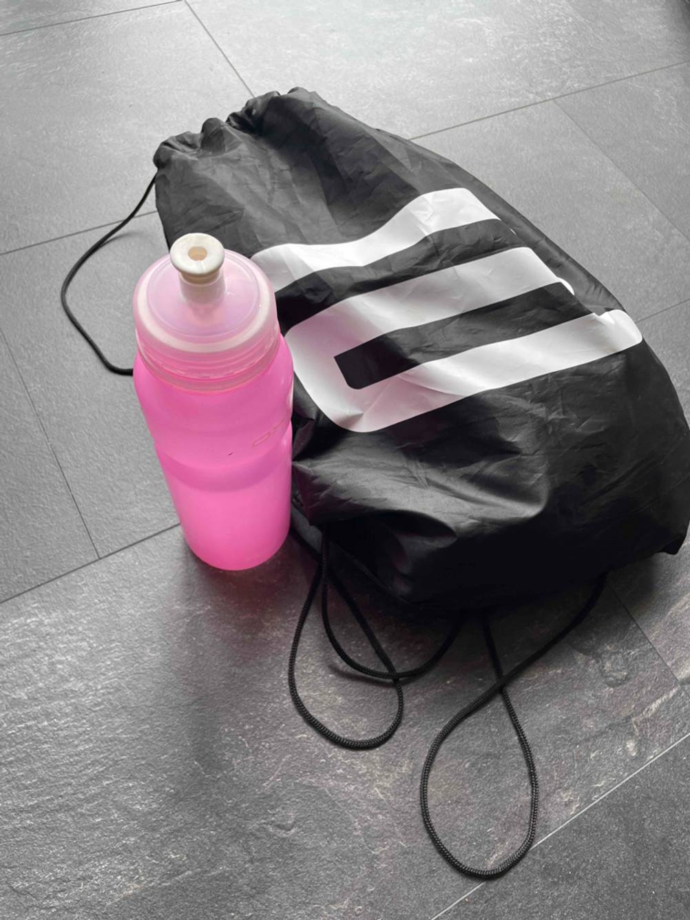 sport-trinkflasche neben Sporttasche 