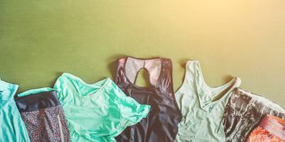 Mehrere Stücke Funktions-Sportkleidung, die zerknittert und schmutzig sind, liegen nebeneinander ausgebreitet auf einer Sportmatte.