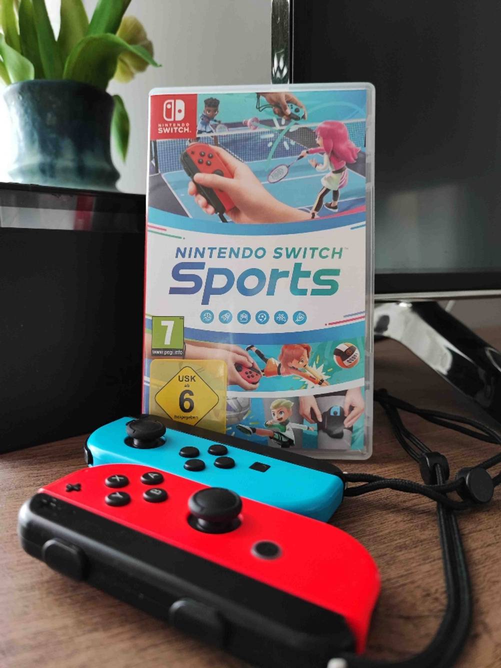 Nintendo-Switch-Spiele im Test: Sports in der Originalverpackung und zwei Nintendo-Switch-Controller.