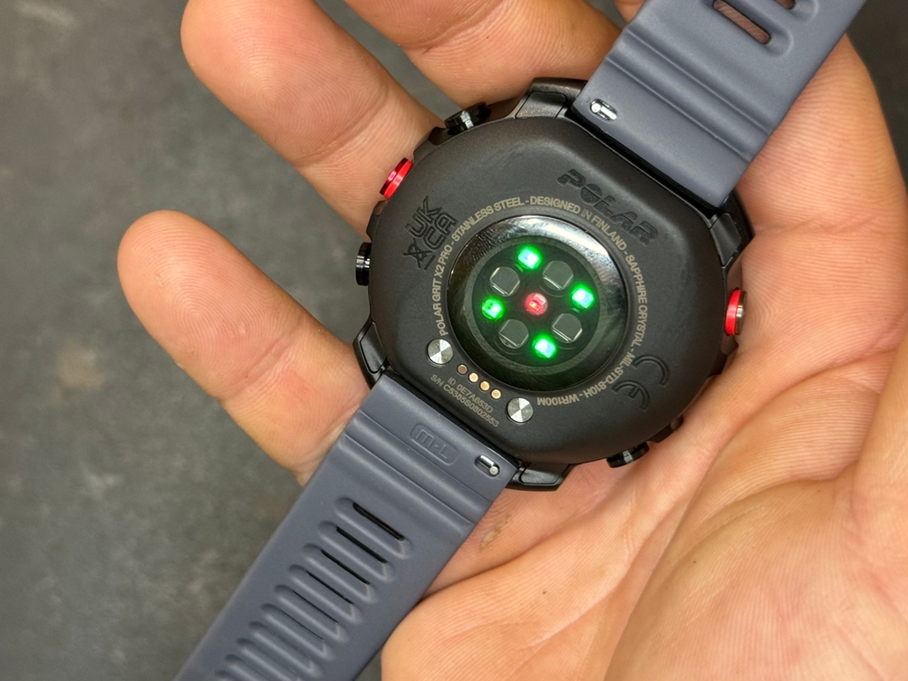 Eine Hand hält die Polar-Sportuhr mit der Unterseite nach oben.