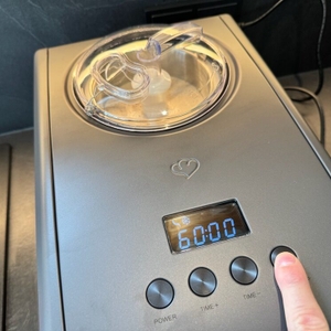 Eine Hand drückt einen Knopf auf der Springlane Kitchen Emma.