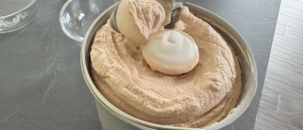 Mit einem Eislöffel der Springlane Kitchen Emma wird fertiges Eis aus dem Behälter entfernt.