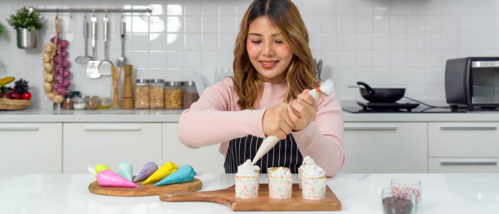 Spritztüllen-Test: Frau verziert Cupcakes mit Spritztülle.