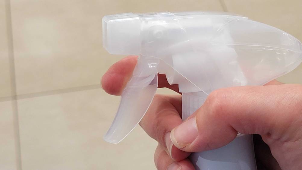 Sprühflasche im Test: Nahaufnahme des Sprühkopfes von einer Hand gehalten.