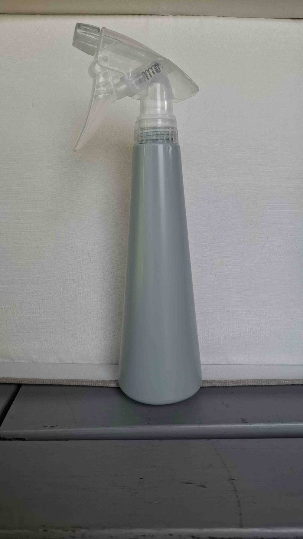 Eine getestete Sprühflasche vor einer hellen Fläche.