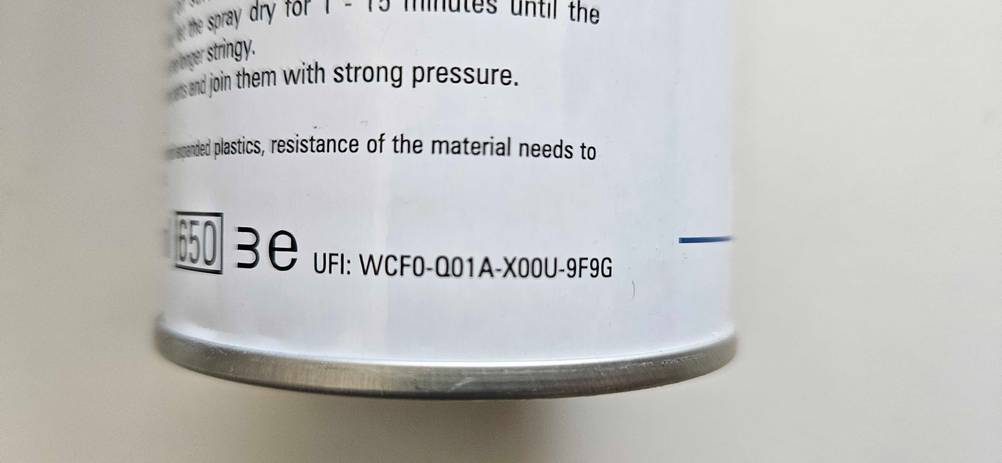 Nahaufnahme der UFI-Rezepturidentifikators auf der Rückseite einer Dose Sprühkleber im Test.