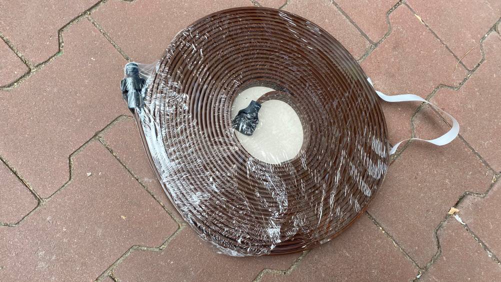Ein getesteter Sprühschlauch liegt verpackt auf dem Boden.