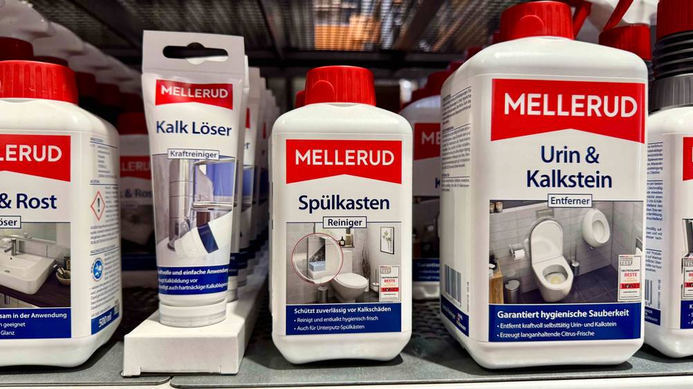 Mehrere Packungen des getesteten Spülkasten-Entkalkers stehen neben anderen Produkten in einem Verkaufsregal.
