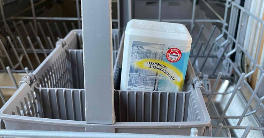 Nahaufnahme der umgedrehten Flasche des getesteten Spülmaschinenreinigers in einem Besteckkorb.