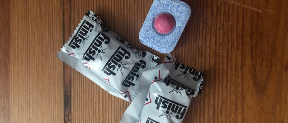 Finish-Spülmaschinentabs sowohl eingepackt als auch ausgepackt in Frontalansicht.