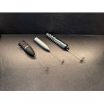 Drei Stab-Milchaufschäumer liegen nebeneinander auf einer Küchen-Arbeitsplatte.