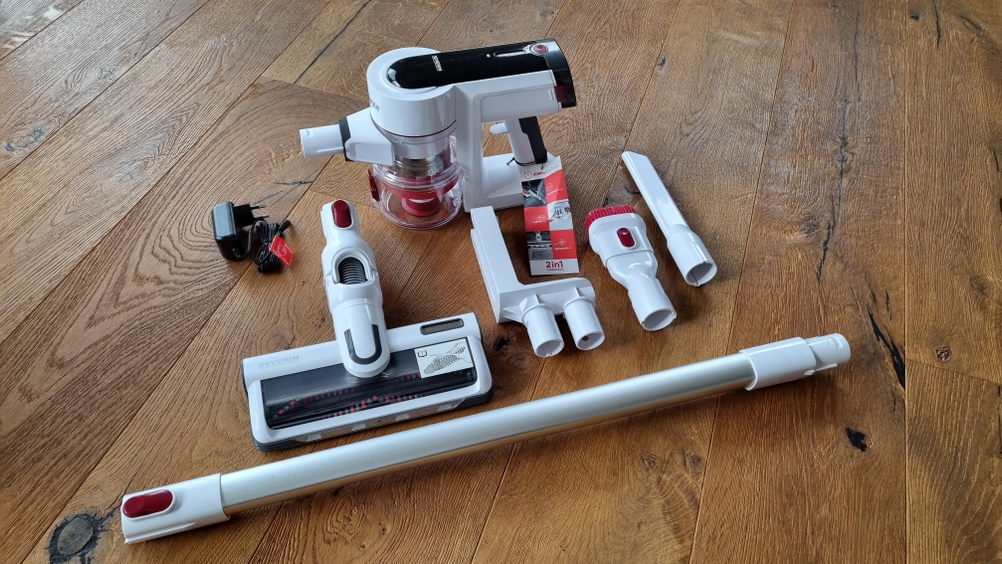 Stabstaubsauger in einzelnen Teilen liegt auf dem Boden.