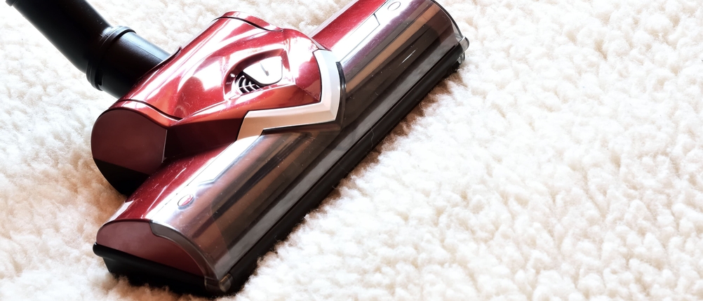 Nahaufnahme einer Bodendüse, die über einen flauschigen Teppich gleitet.