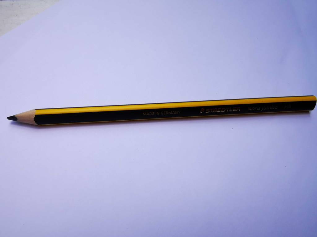 Ein Zimmermannsbleistift liegt zum testen auf einer weißen Fläche.