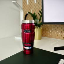 Der Thermobecher Stainless King von der Marke Thermos steht auf einem Schreibtisch neben einer Tastatur.