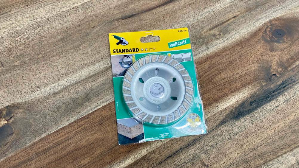 Diamant-Schleiftopf getestet: Ein Produkt in seiner transparenten Originalverpackung auf einer Holzfläche.