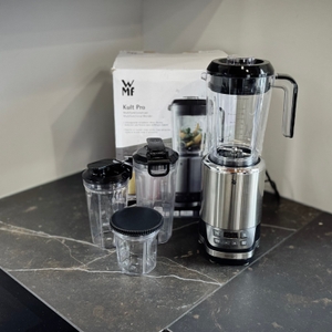 Der getestete Standmixer WMF Kult Pro steht zusammen mit dem Zubehör vor dem Karton.