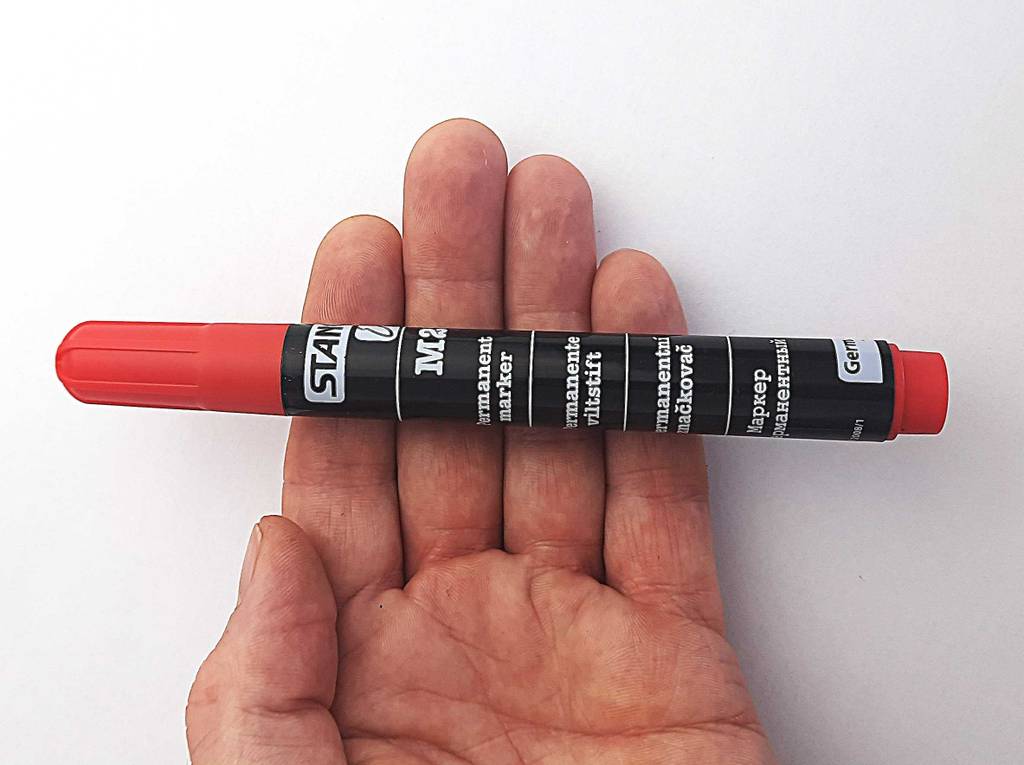 Auf der Innenhandfläche über einer weißen Oberfläche liegt der Alkoholmarker im Test.
