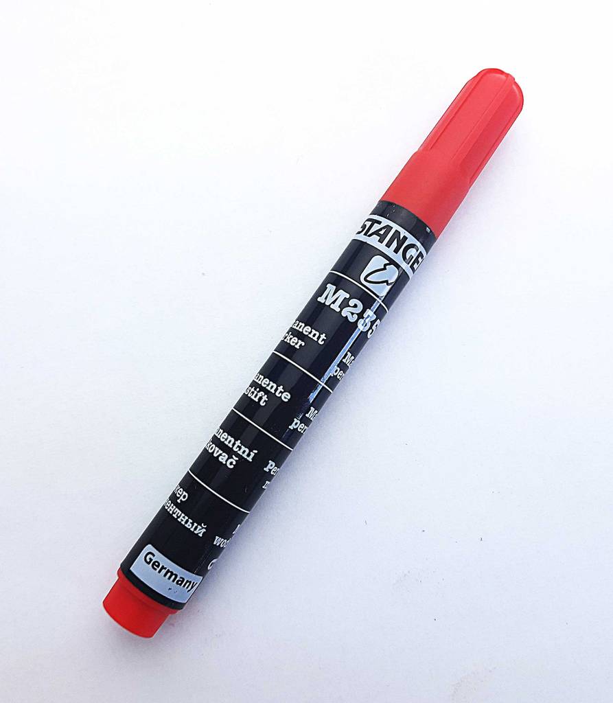 Alkoholmarker-Test: Ein schwarzer Stift mit roter Verschlusskappe liegt auf einer weißen Oberfläche.