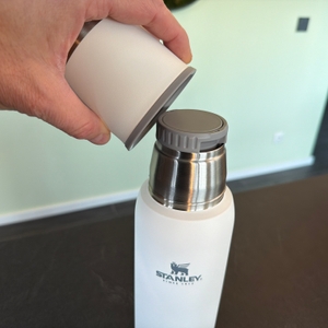 Eine Hand nimmt den Trinkbecher von der Stanley Adventure To-Go