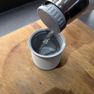 Wasser wird aus der Stanley Adventure To-Go in ihren Trinkbecher gegossen