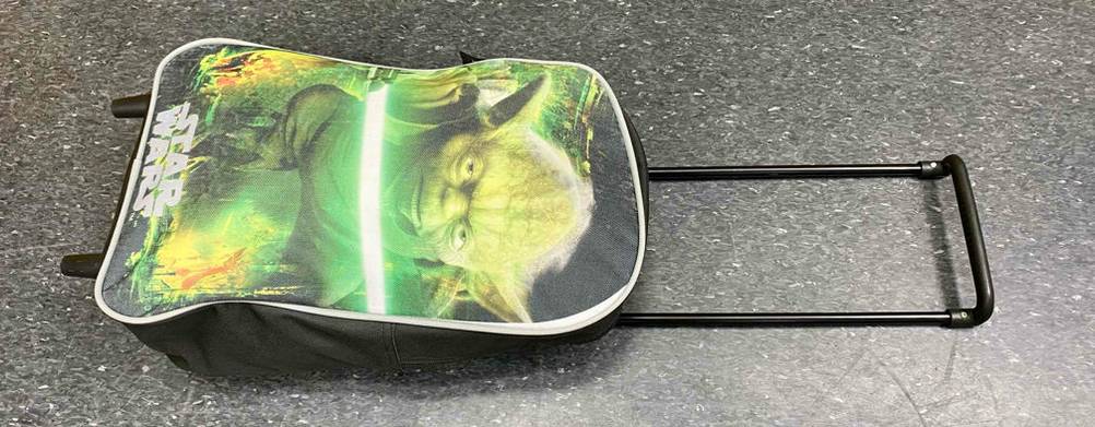 Ansicht von oben auf einen Starwars Kindertrolley im Test mit herausgezogenem Griff auf schwarzem Boden.