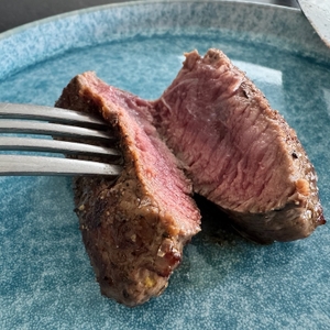 Aufgeschnittenes Steak auf einem blauen Teller nach dem Braten mit der Staub 1004370