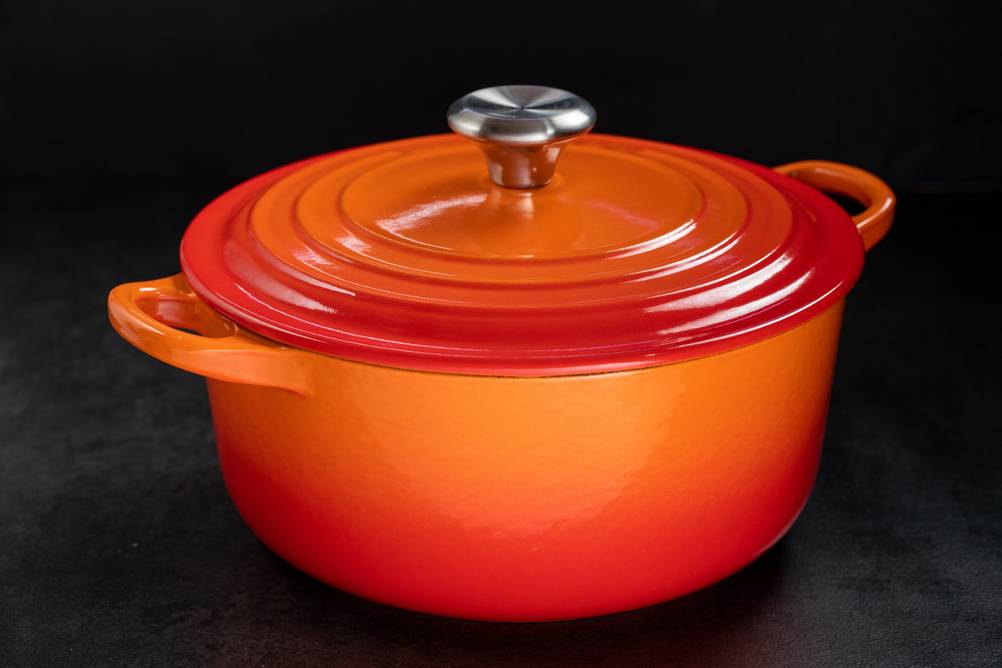 STAUB-Bräter im Test: orangefarbener Dutch Oven auf schwarzem Untergrund