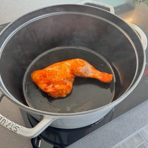 Ein Stück Fleisch liegt während des Bratens auf dem Herd im Staub Cocotte 1007460