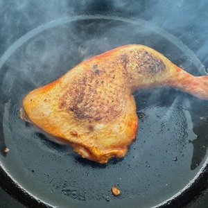 Ein Stück Fleisch liegt im Behälter des Staub Cocotte 1007460 während des Bratens auf dem Herd