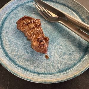 Angebratenes Steak auf dem Teller mit Messer und Gabel