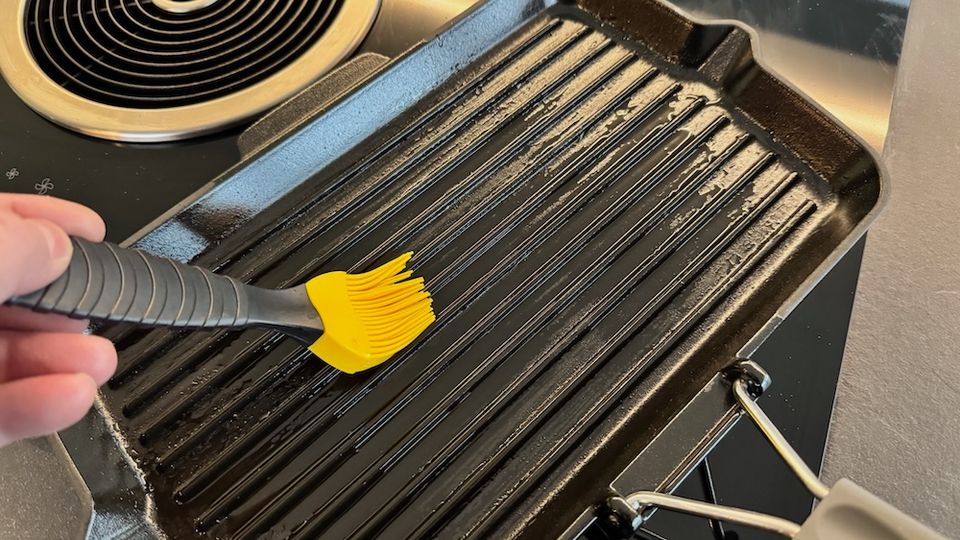 Staub-Grillpfanne Gusseisen wird mit einem Pinsel eingeölt