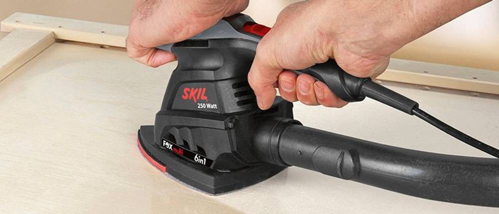 Multischleifer von Skil mit angeschlossener Staubabsaugung.