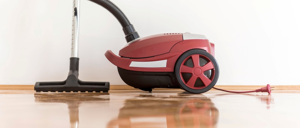 Staubsauger mit Beutel im Test: roter Staubsauger steht auf Parkett