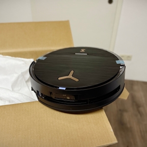 Der Staubsaugerroboter steht auf der Verpackung.