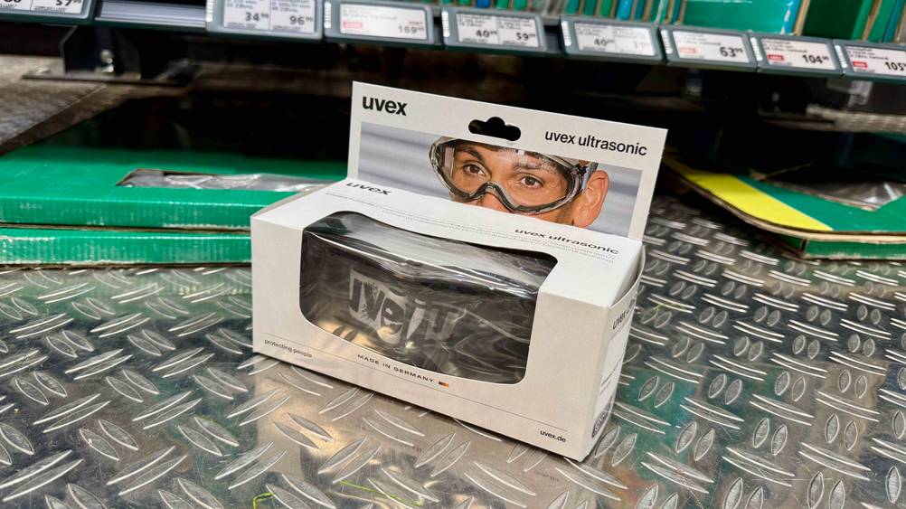 Auf einer Metallfläche steht die verpackte Staubschutzbrille im Test.