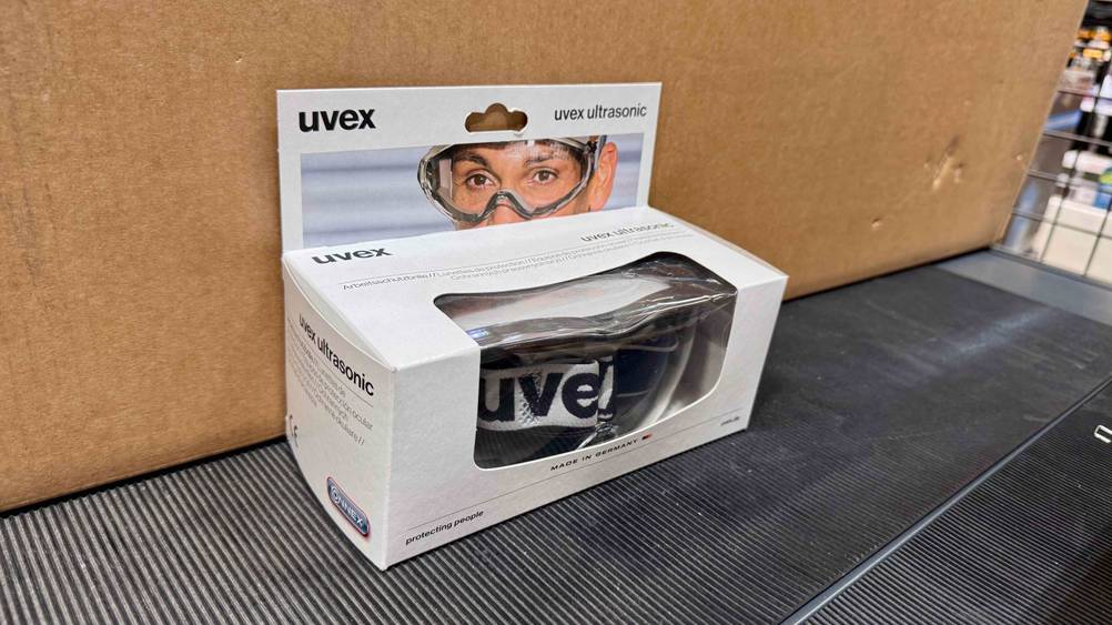 Vor einem Karton befindet sich die getestete Staubschutzbrille.